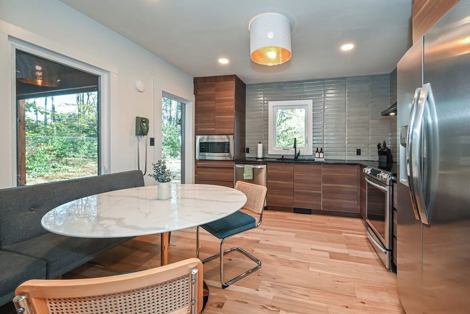 This modern, fully stocked kitchen features stainless appliances, plenty of counter space, and a cozy dining area for up to five guests.