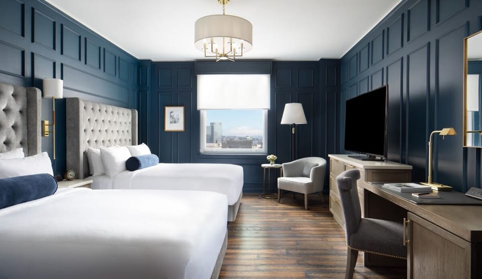 Unwind in a serene, sunlit room with plush double queens.