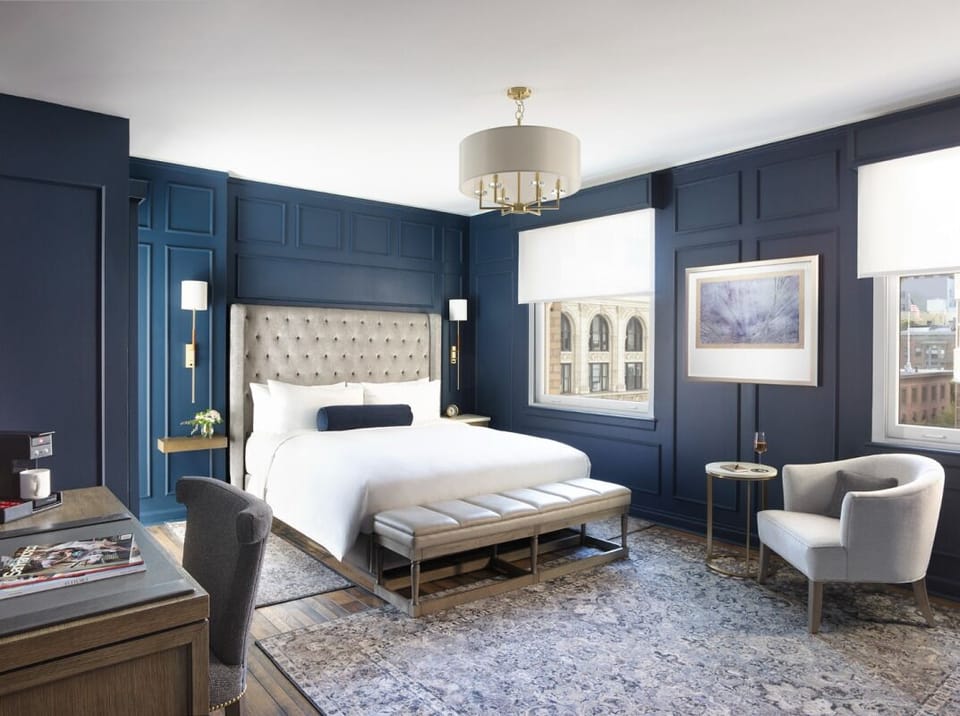 Wake up to sunlit windows in a designer navy retreat.