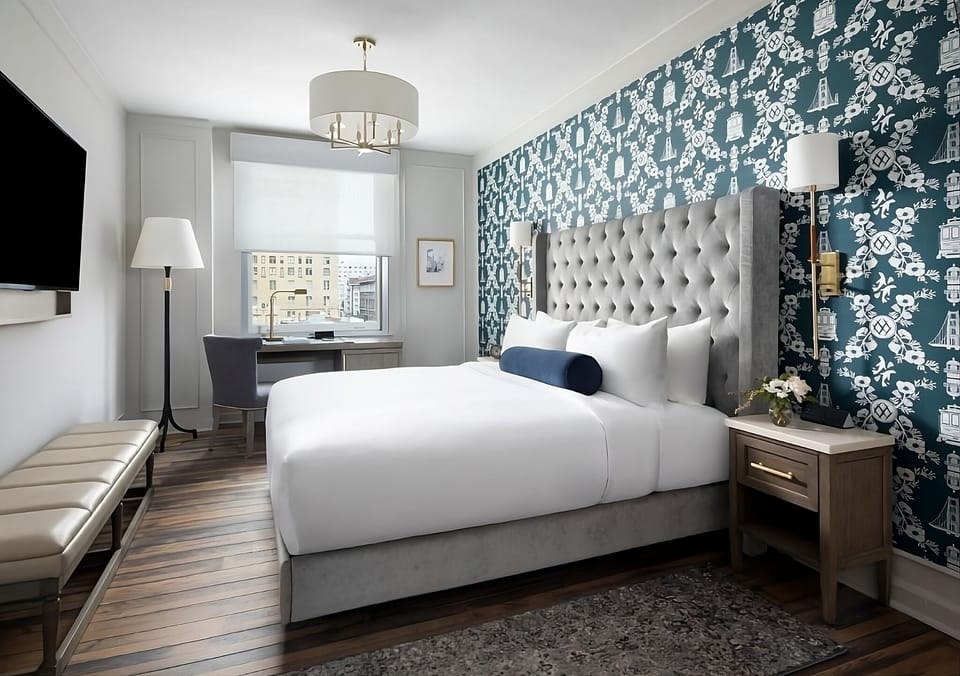 Sink into crisp linens beneath a statement tufted headboard.