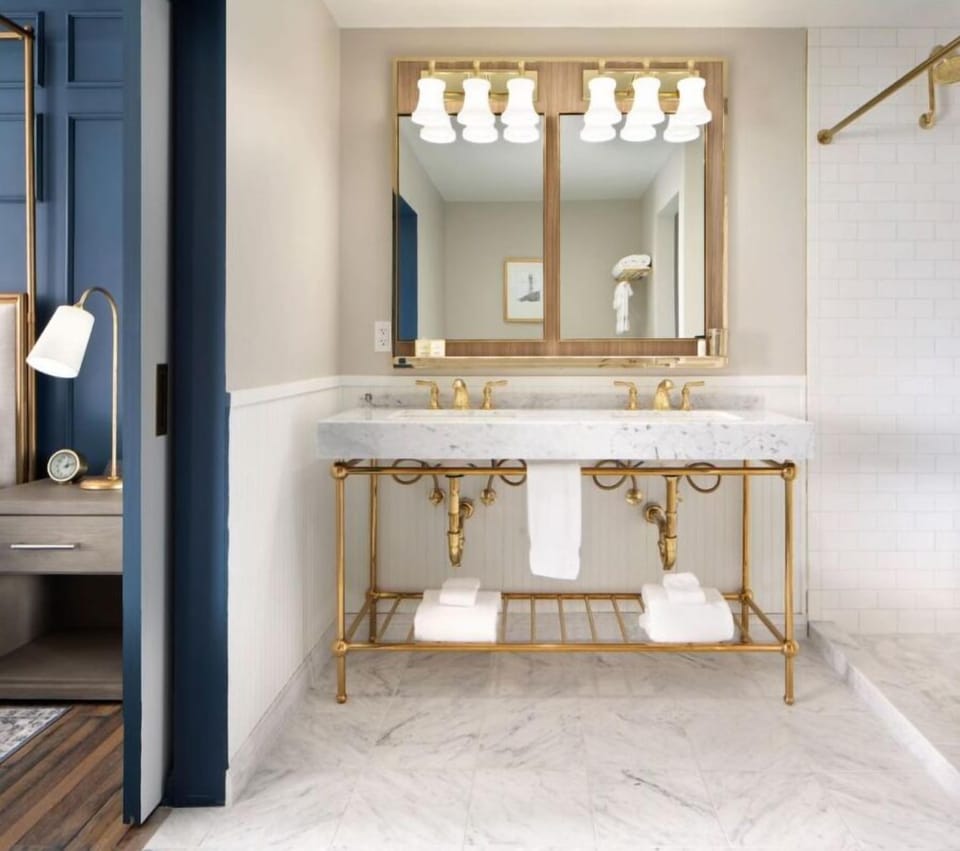 Refresh each morning with marble vanity and warm brass glow.