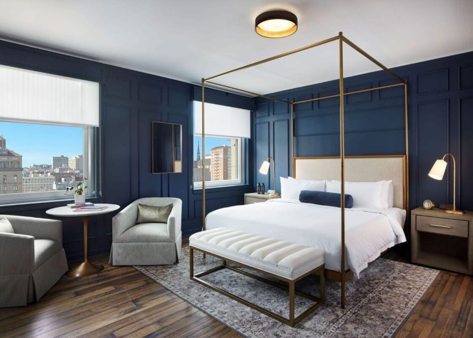 Stretch out in a glamorous canopy bed with city views.