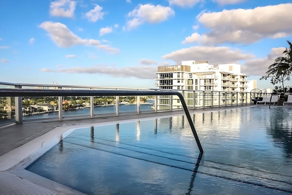 Glide into the rooftop pool with sweeping bay views.