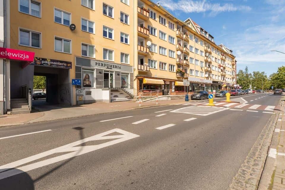 Another perspective of the lively street, highlighting the vibrant yellow buildings and shops, adding charm to the area.

