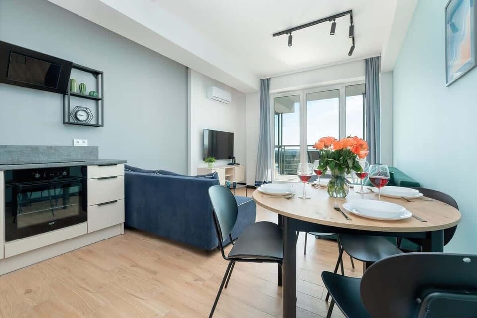 A modern kitchen with white cabinets, black appliances, and a sleek design that maximizes functionality.

