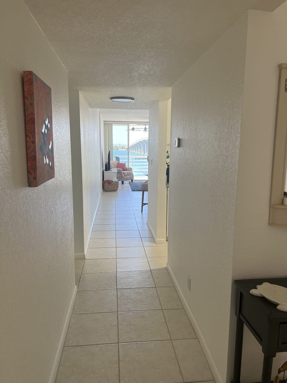 View from the entryway looking down the hall to the living room and balcony