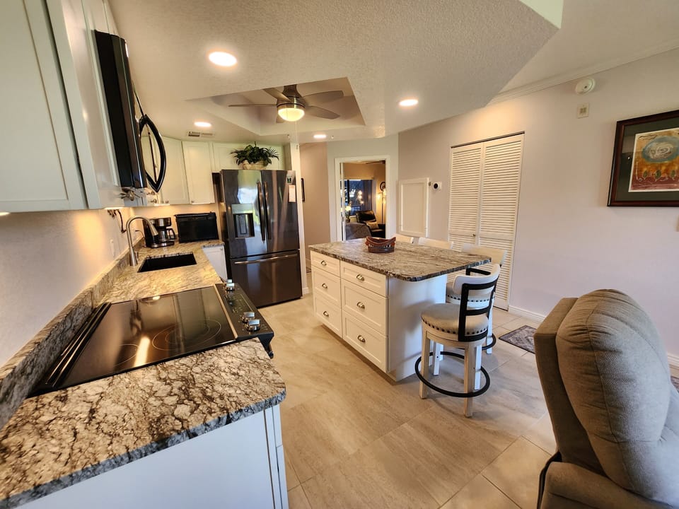 Kitchen from living room, granite countertops and 4 ceiling fans throughout unit