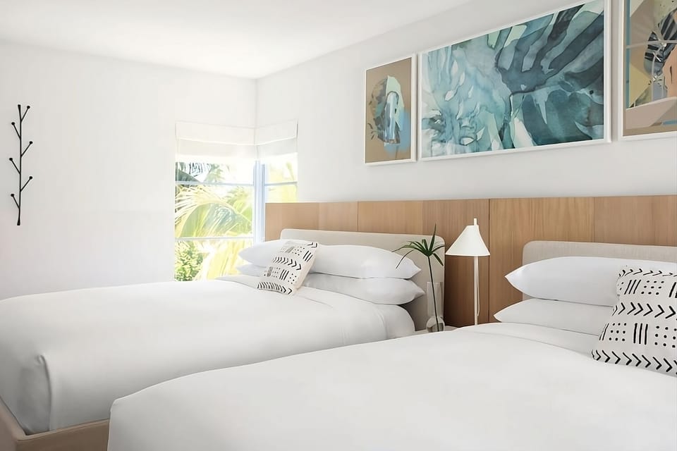Drift off in cloud-soft bedding beneath calming coastal artwork.