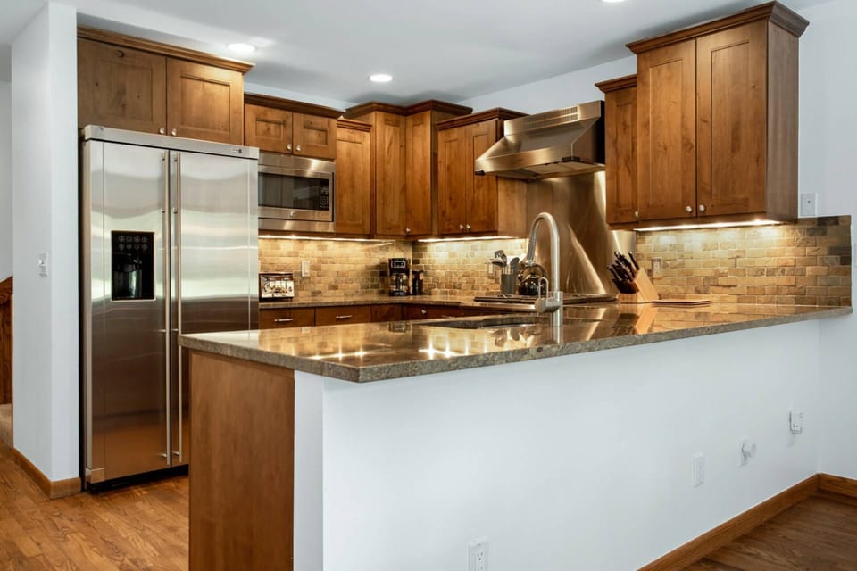 Under cabinet lighting adds extra warmth to the ambiance of this modern kitchen.