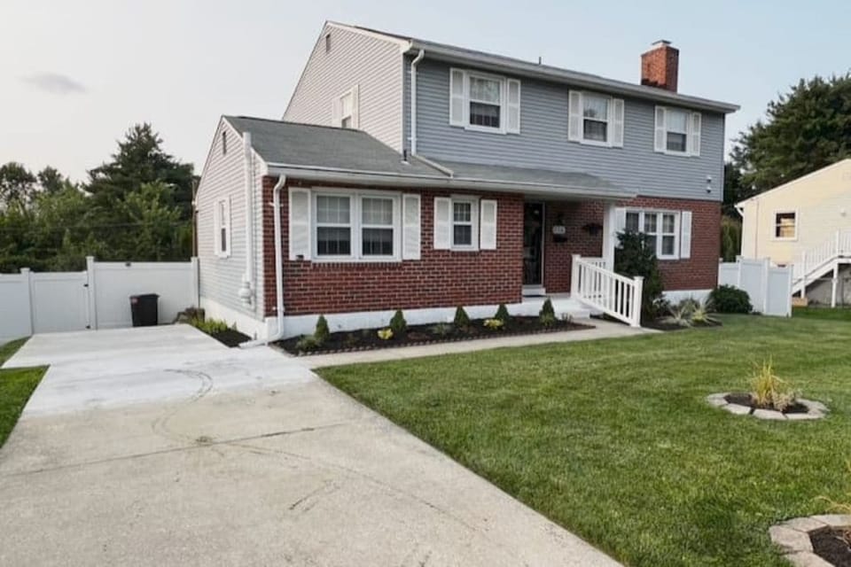 Front view of the house, showing the driveway and the outdoor waste bin dump.