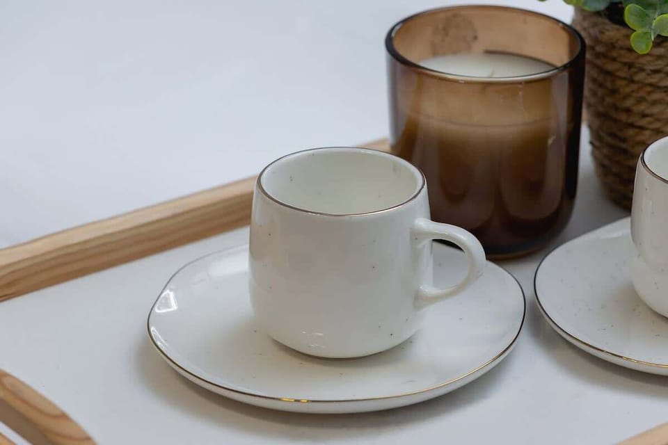 A close-up of a tray with a cup, a saucer, and a decorative candle, adding a touch of hospitality and charm.
