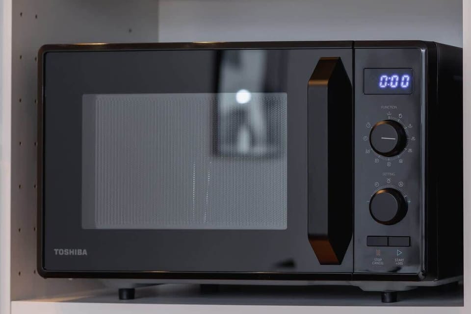 A close-up of a microwave oven, neatly integrated into the kitchen setup for convenience.
