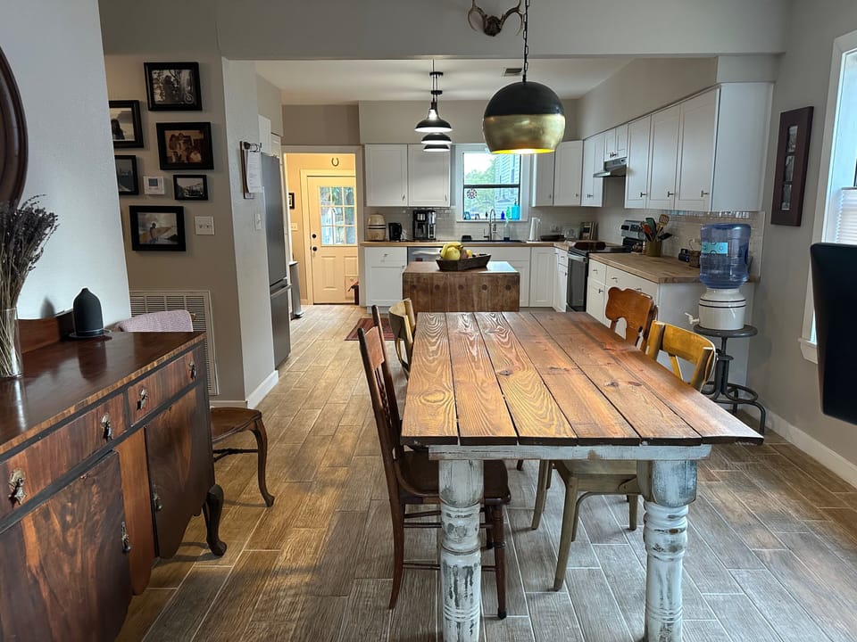 Dining area leading into open-concept kitchen leading to the backdoor. 