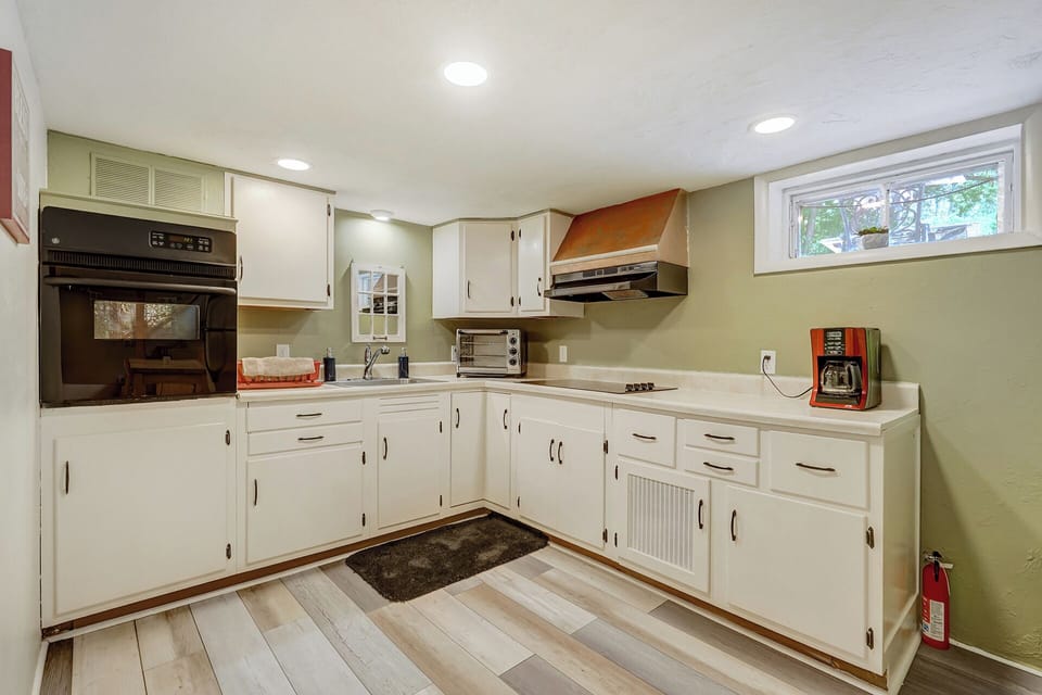 Kitchen with oven, stove, sink, toaster, coffee maker and dishes/pots/utensils