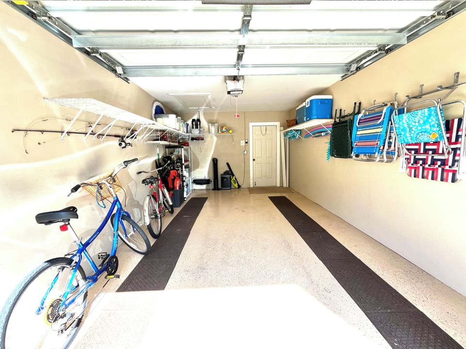 Private garage with 2 bikes, beach chairs, coolers and pool floats.