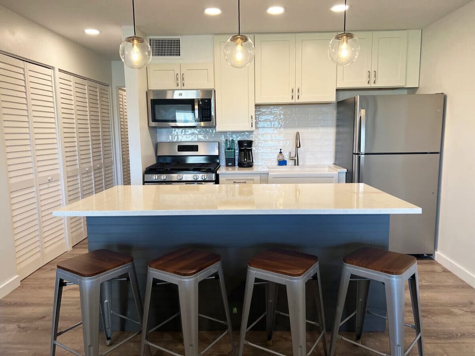 Modern kitchen with a spacious quartz countertop and ample seating for shared meals.