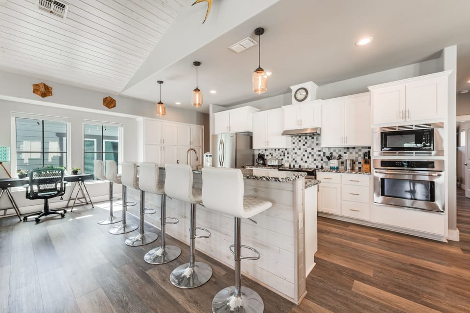 Your sleek kitchen awaits with granite counters, stainless appliances, and stylish seating for culinary adventures and morning coffee rituals.
