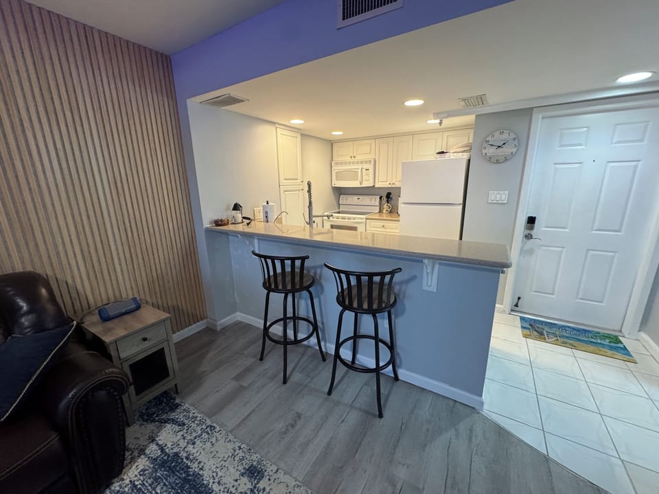 Well lit kitchen & breakfast bar area.