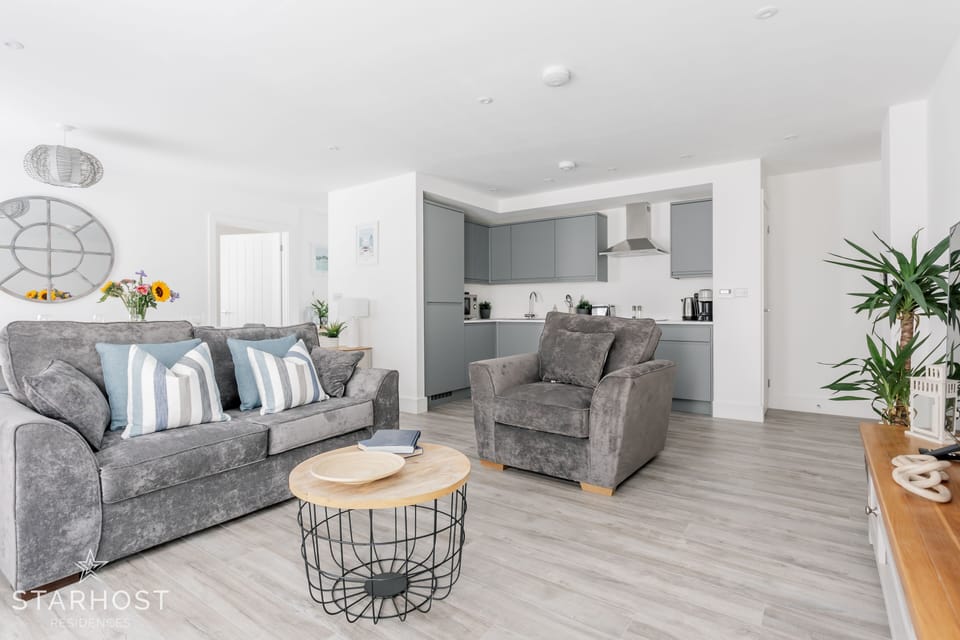 This large living room has a designated lounge, kitchen & dining space