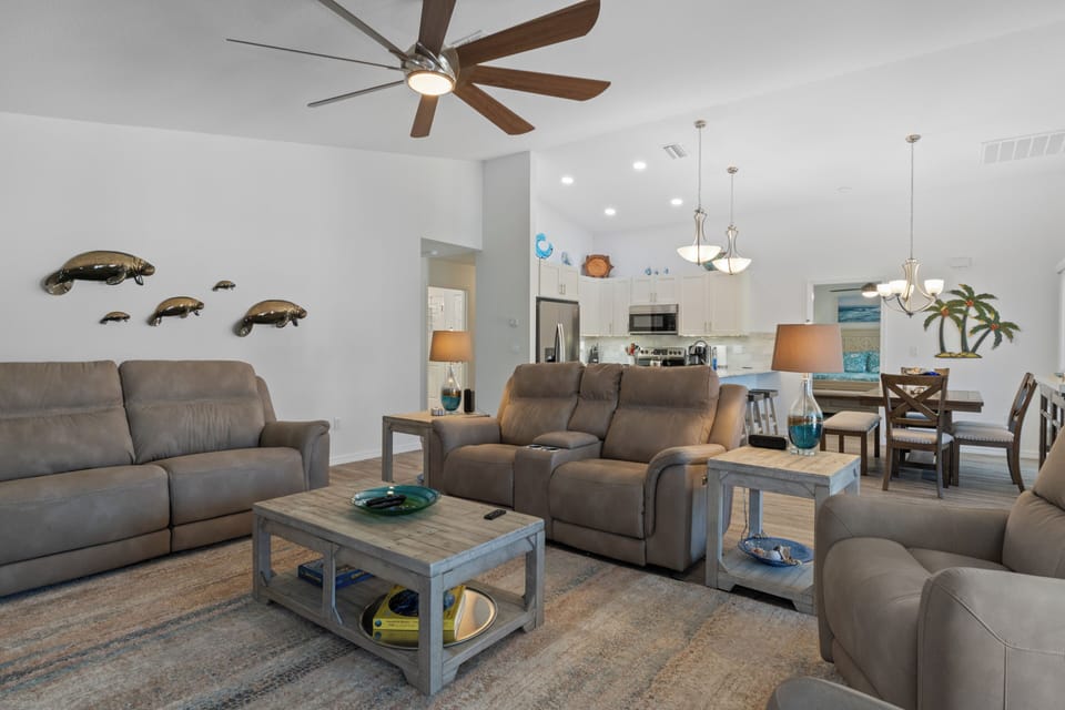 The living room has a 75-inch TV and a sofa with comfortable reclining seats
