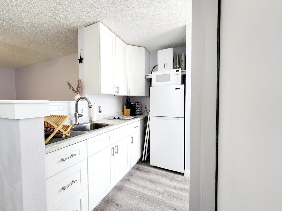 The kitchenette features a refrigerator, freezer, pots/pans, cutlery, and dishes