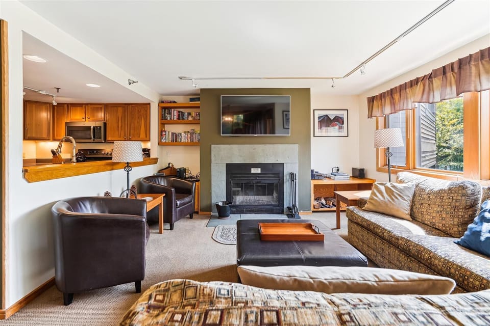 Spacious living room with fireplace, sectional seating, and easy access to the kitchen and dining spaces.