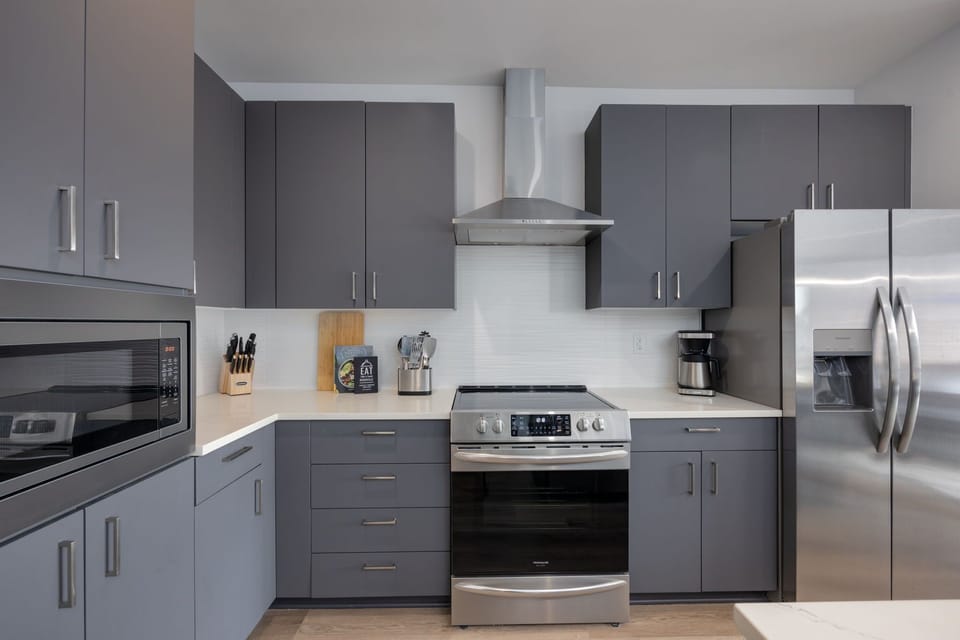Fully equipped kitchen stocked with your basic cooking essentials. Includes stainless steel appliances, small kitchen island, coffee machine, and toaster.