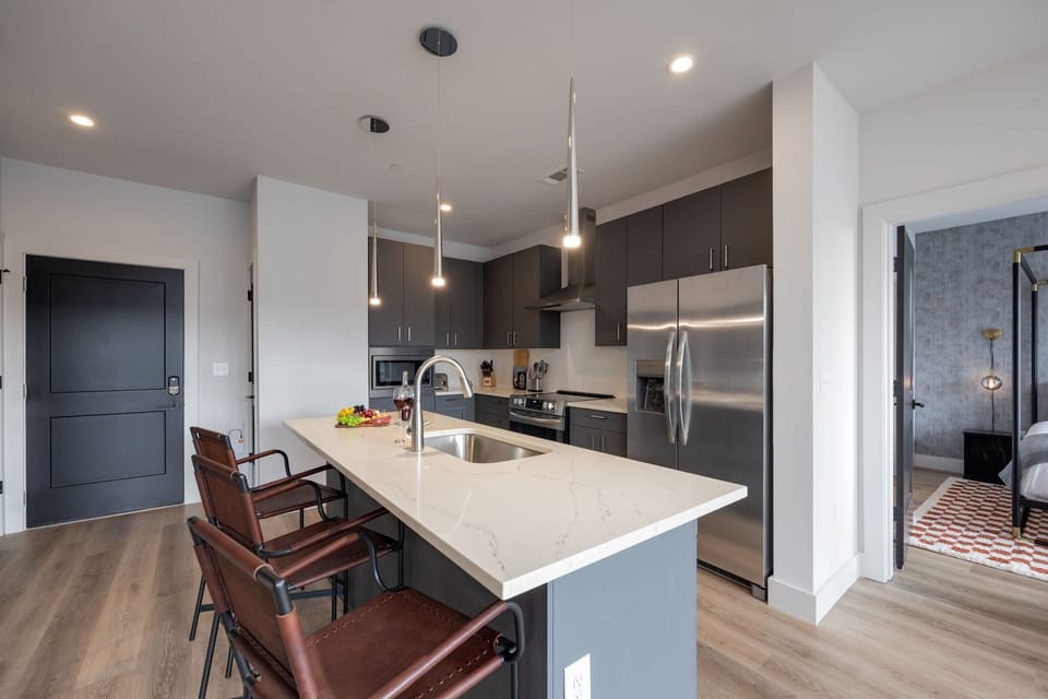 Fully equipped kitchen stocked with your basic cooking essentials. Includes stainless steel appliances, small kitchen island, coffee machine, and toaster.