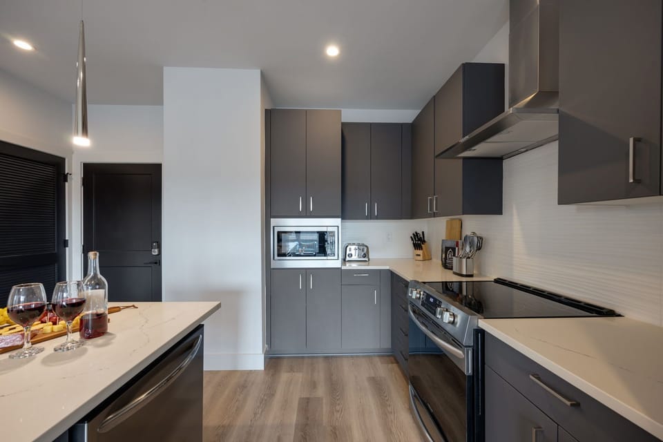 Fully equipped kitchen stocked with your basic cooking essentials. Includes stainless steel appliances, small kitchen island, coffee machine, and toaster.