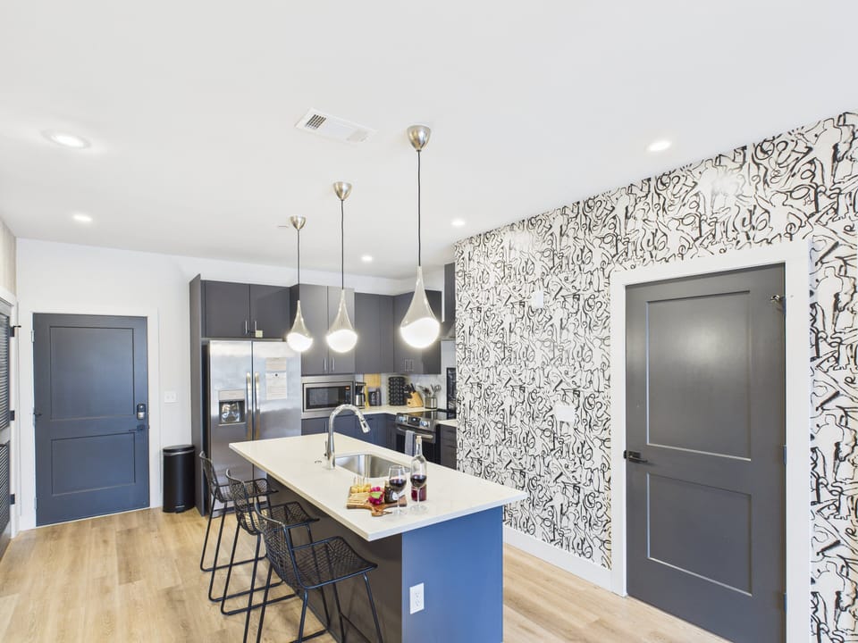 Fully equipped kitchen stocked with your basic cooking essentials. Includes stainless steel appliances, kitchen island, coffee machine, and toaster.