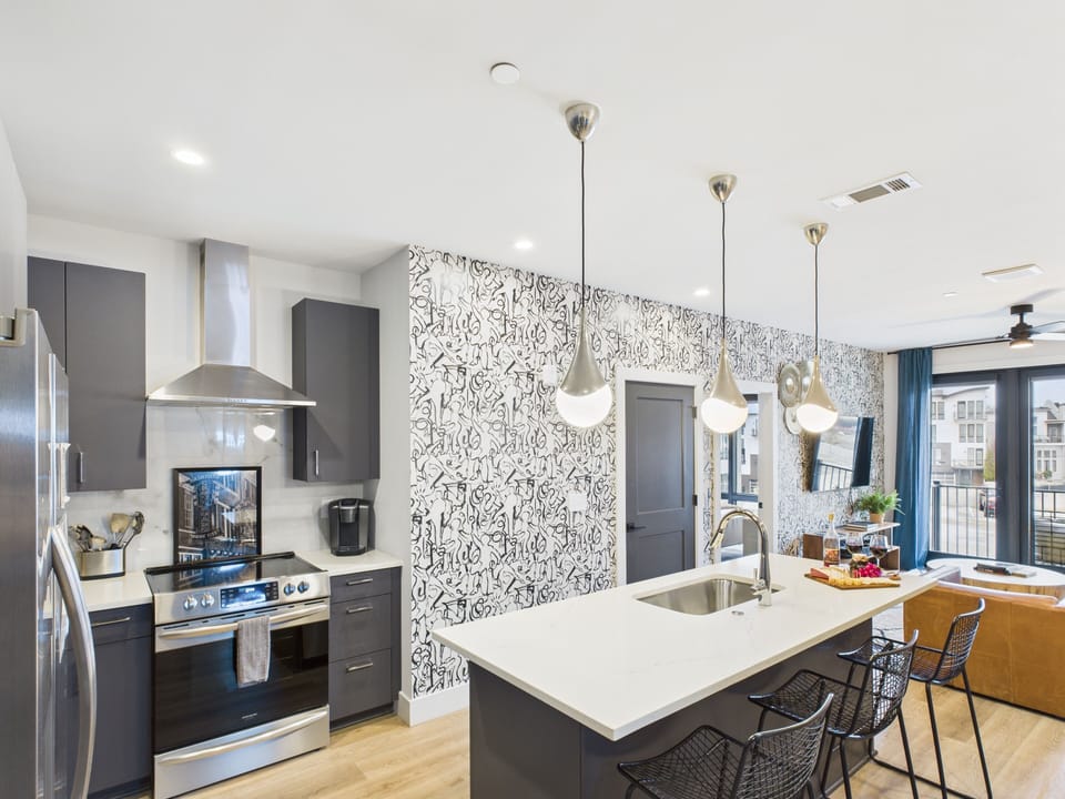Fully equipped kitchen stocked with your basic cooking essentials. Includes stainless steel appliances, kitchen island, coffee machine, and toaster.