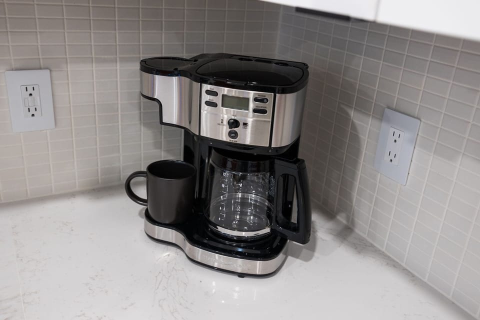 Fully equipped modern kitchen with stainless steel appliances and basic cooking essentials.
