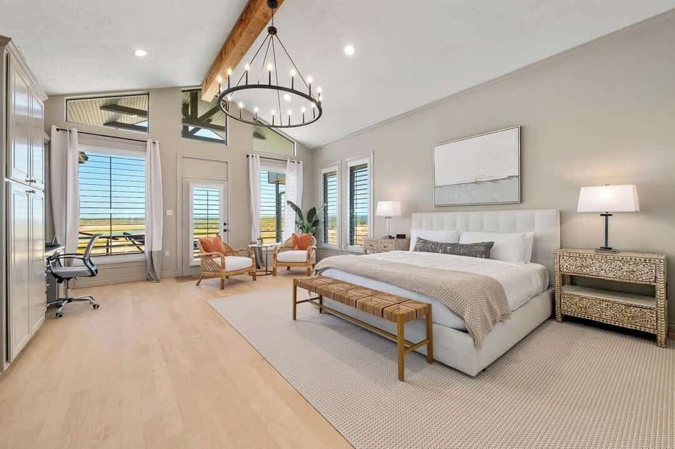 Bedroom 1- There is a King size bed, seating area, built-in workspace, patio access, and an ensuite bathroom.