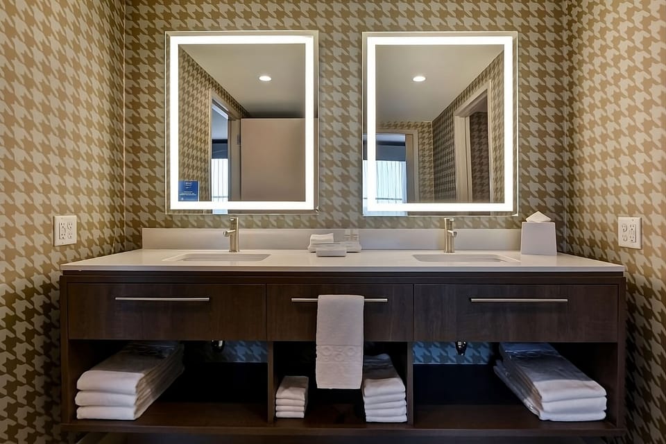 Get ready easily with a double vanity and glowing mirrors.