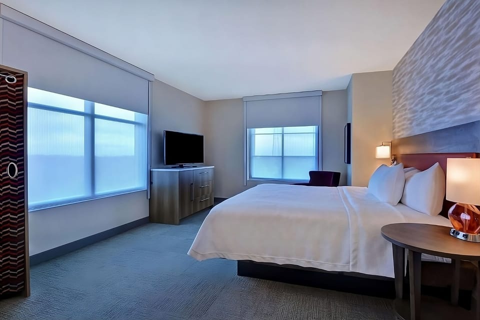 Stretch out in a bright room with TV and oversized windows.