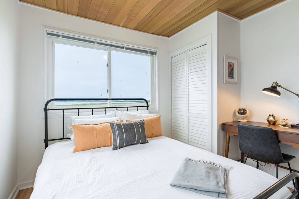 Primary bedroom features a queen bed and a desk.
