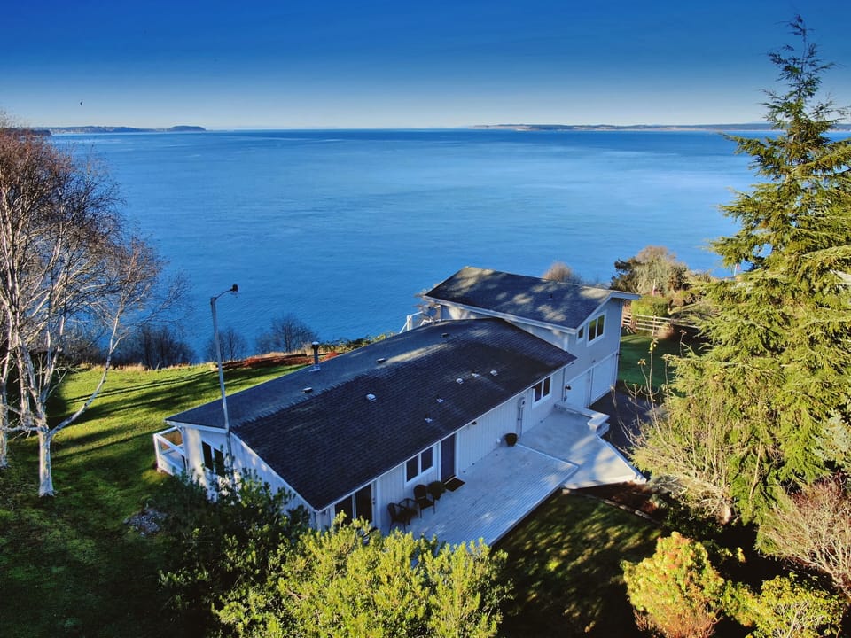 Nestled on an elevated waterfront, this charming residence presents stunning 180° vistas of Admiralty Inlet and the San Juan Islands.