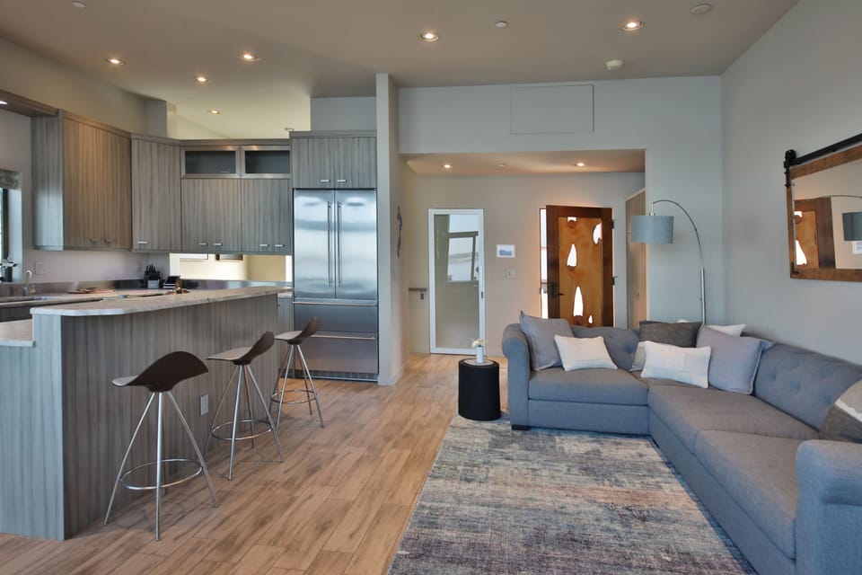 Open concept living and kitchen space in cool gray tones.