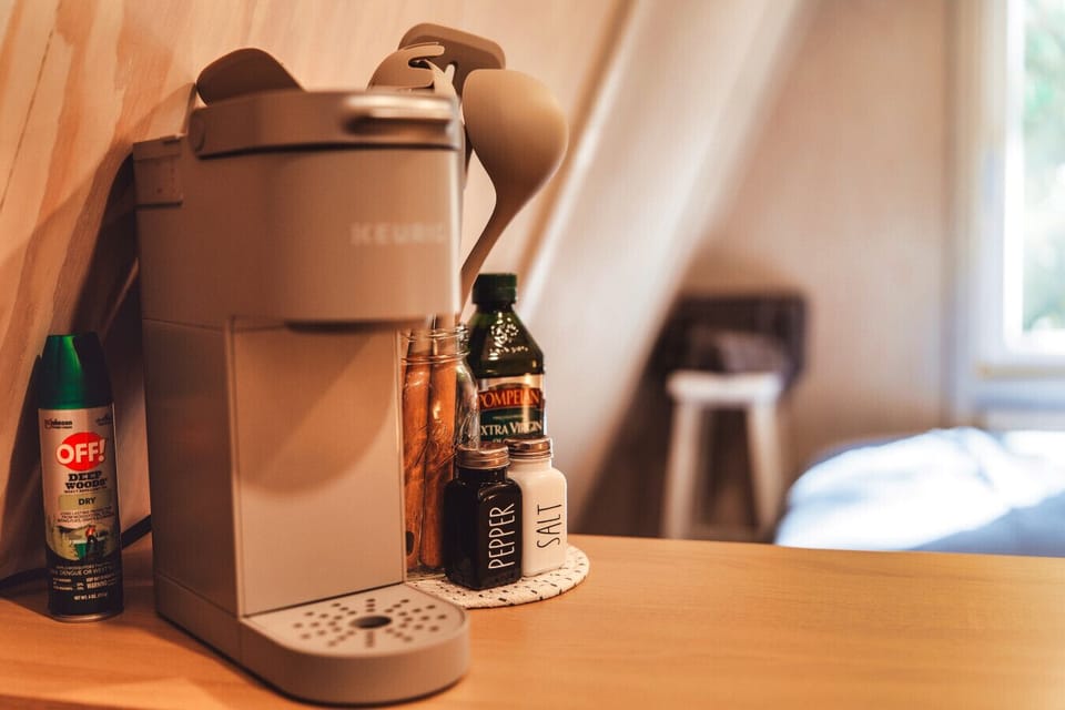 The A-frame comes with a Keurig machine, mini fridge, and the dining basics.