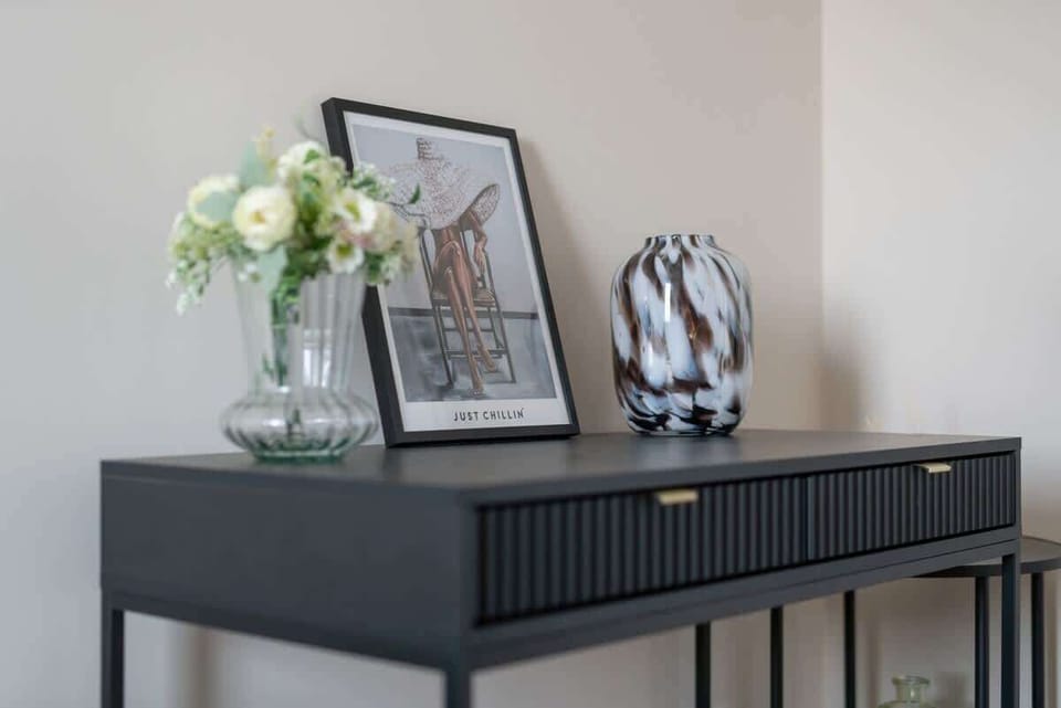 A hallway featuring a small console table with decorative elements and neutral tones, adding a touch of sophistication.
