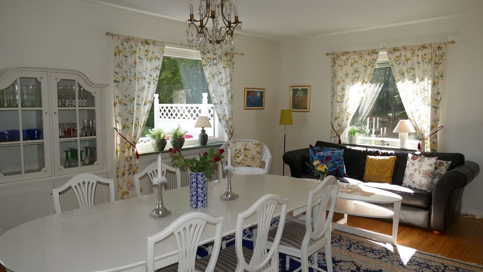 Livingroom with open fireplace. Dining table. Door out to the terasse.