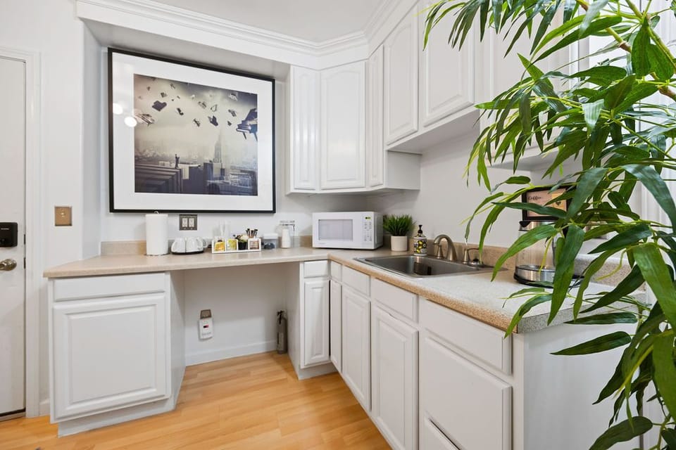 kitchen with white cabinets, warm wood, and light that lingers.