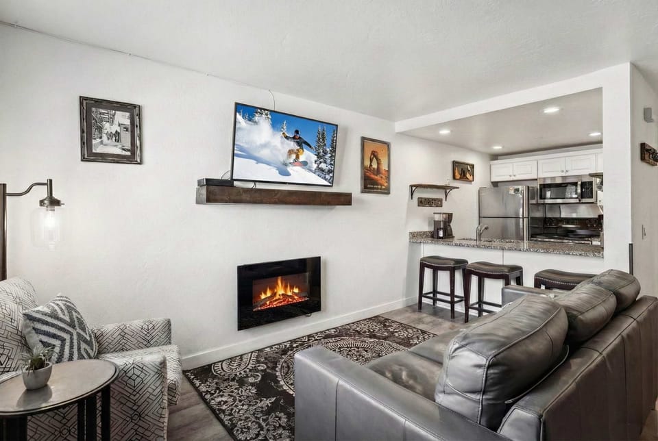 Living room: leather couch, reading chair, a 50” TV, electric fireplace