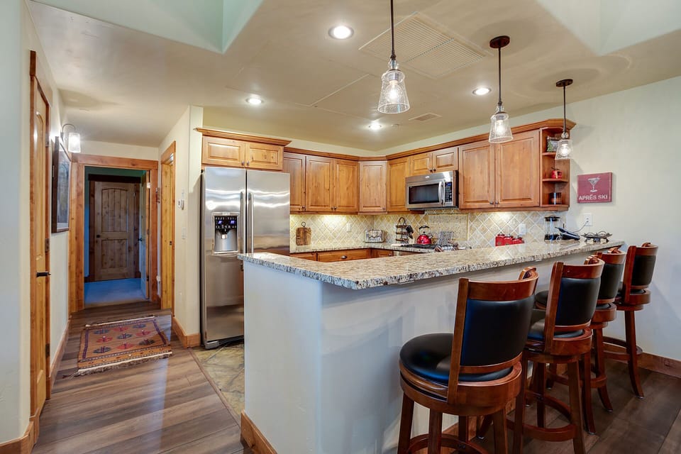 Your spacious kitchen welcomes you with warm wood cabinets, granite countertops, and a breakfast bar where you can sip morning coffee together.