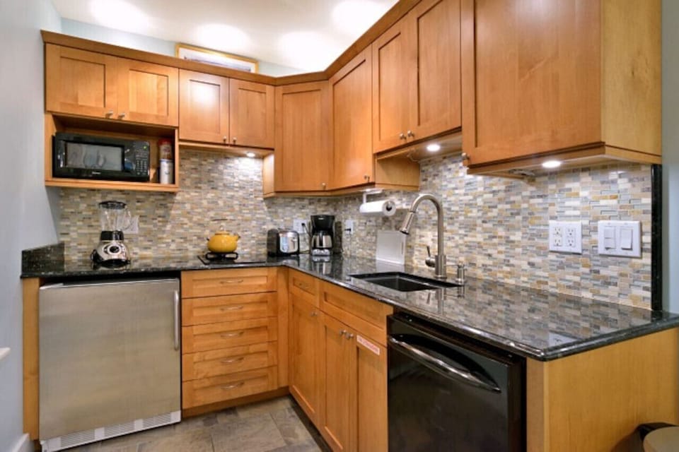 Kitchen with granite counter tops, dishwasher, 2 burner glass top stove, microwave, refrigerator with freezer, toaster, coffee maker, blender, all paper products, soaps, dishes, pots, cutlery.