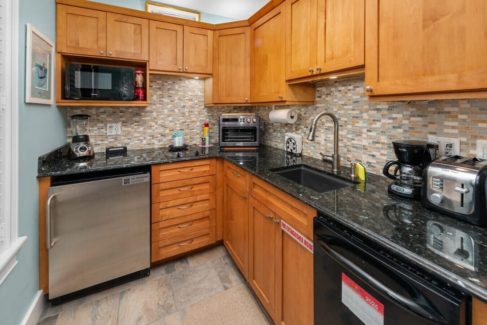 Black granite with blue sparkles!  The kitchen has an under-counter refrigerator/freezer, microwave, 2 burner electric cook-top, blender, air-fryer/oven, everything you need or want!