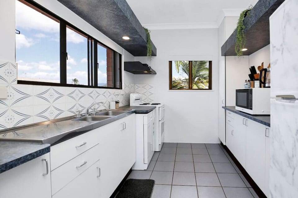 Kitchen: Bright and airy space with modern appliances and a view of lush palm trees outside!