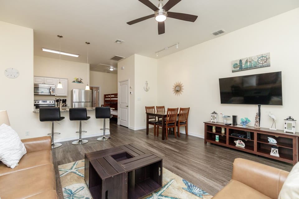 Relax in your spacious living area with leather seating, entertainment center, and open kitchen - perfect for memorable vacation moments together.