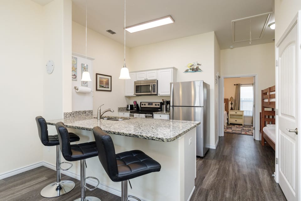Your modern kitchen features granite countertops, stainless steel appliances, and a breakfast bar perfect for morning coffee or casual meals together.