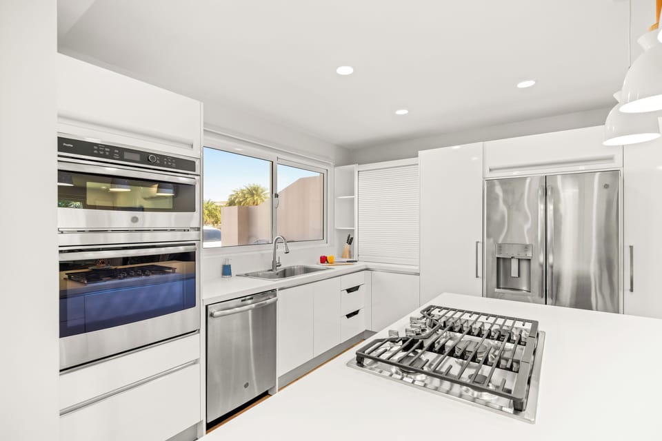 Gas cooktop, oven, microwave, dishwasher, and stainless steel fridge.